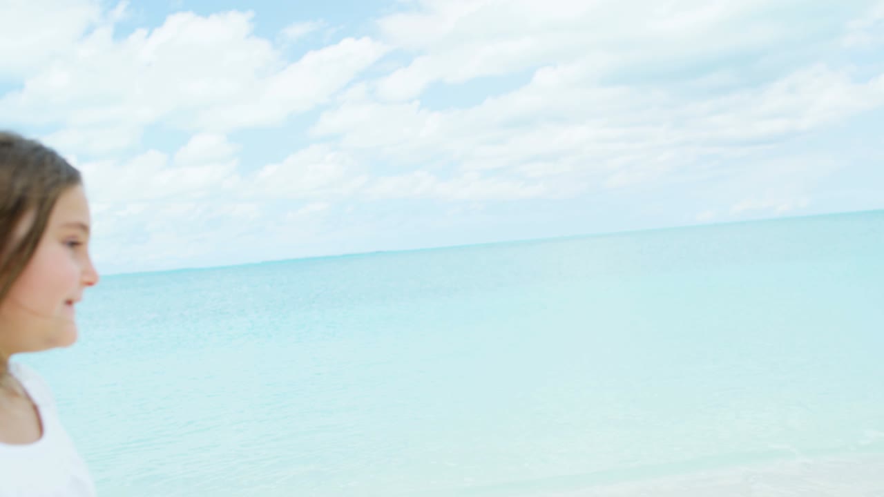 바다 해변에서 여자 아이들을 가진 백인 부모