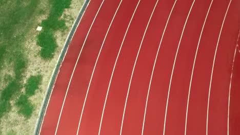 running track at the stadium, color is orange brick, high angle view by drone.