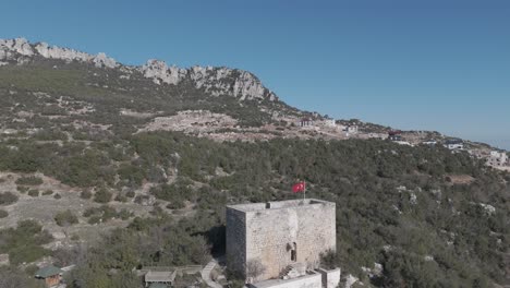 the flag on top of the castle building on the mountaintop, belenkeşlik castle, turkey