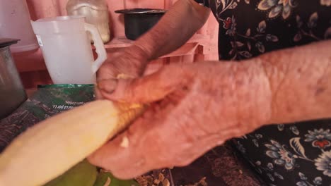 old woman peeling bananas in a rural kitchen