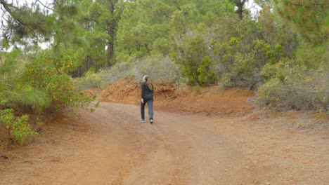 Woman-walking-in-slow-motion-on-natural-path-leading-to-Guimar-Valley