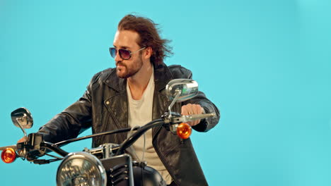 Man,-fashion-and-motorbike-in-studio-on-blue