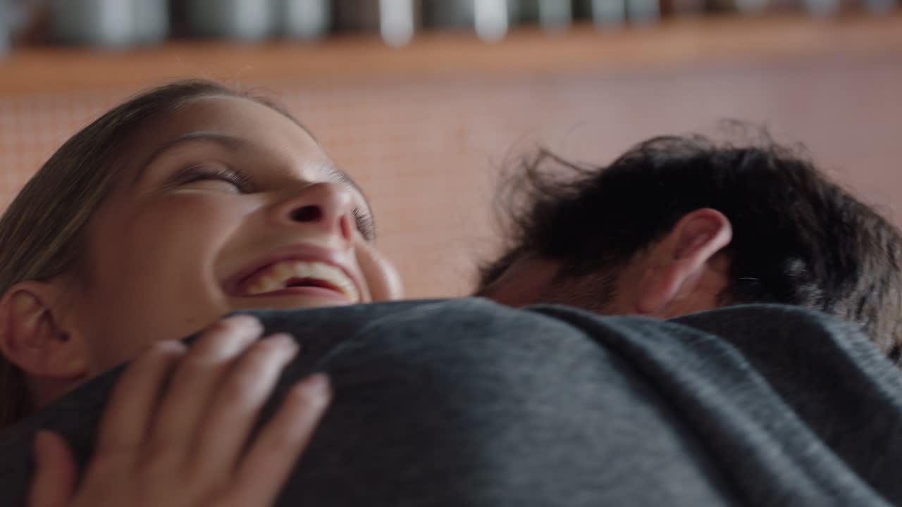 coppia felice che si abbraccia donna eccitata che abbraccia il fidanzato che condivide buone notizie che gode di una relazione romantica a casa