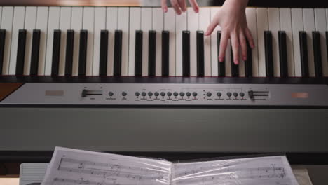 child turns page of music folder playing synthesizer