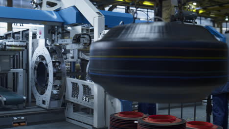 tire factory storage employees controlling production process on modern machine