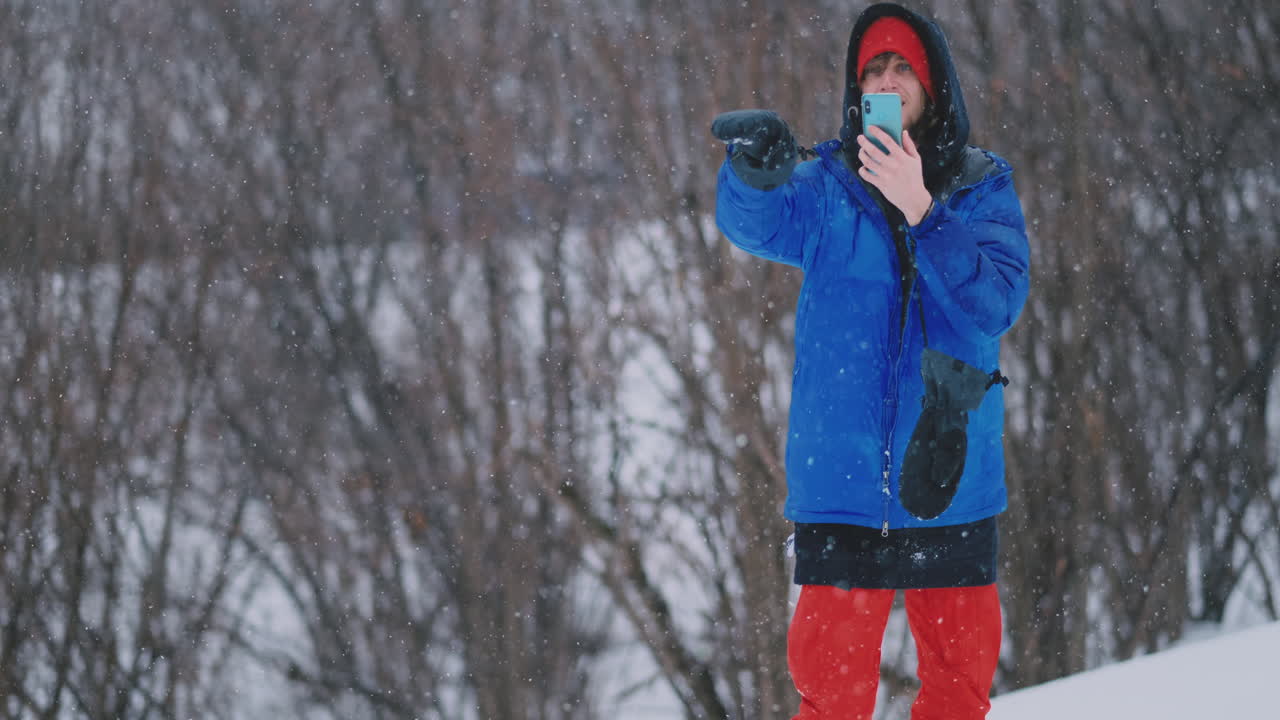 snowboarder lanza una bola de nieve a la cámara parada en la pista de esquí
