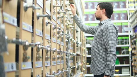 man shopping for door handles in a hardware store