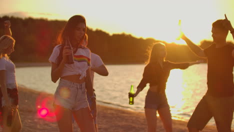 la chica de cabello oscuro está bailando con la cintura desnuda en la fiesta al aire libre con cerveza. es una fiesta de playa loca y caliente con los mejores amigos de buen humor.