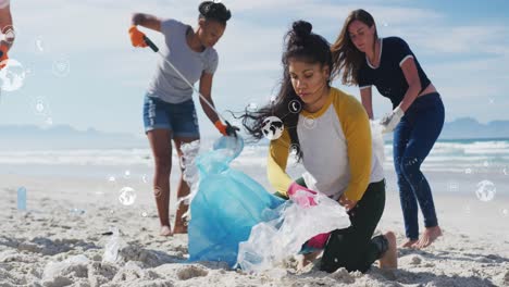 Animation-of-globe-icons-over-diverse-female-volunteers-picking-up-rubbish-on-beach