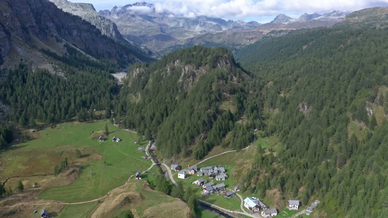 lago di devero, alpe devero con casas rústicas, campos verdes y bosques circundantes a la luz del día, vista aérea