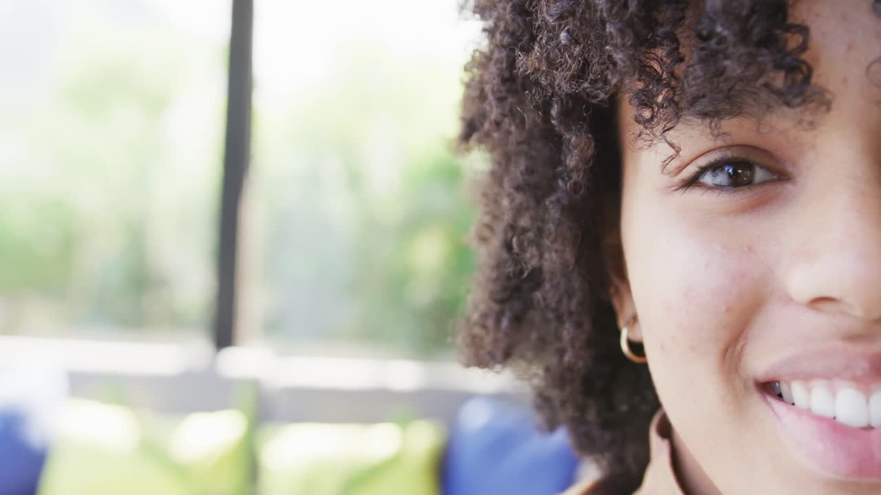 Half face portrait of happy african american teenage girl, smiling and laughing, slow motion