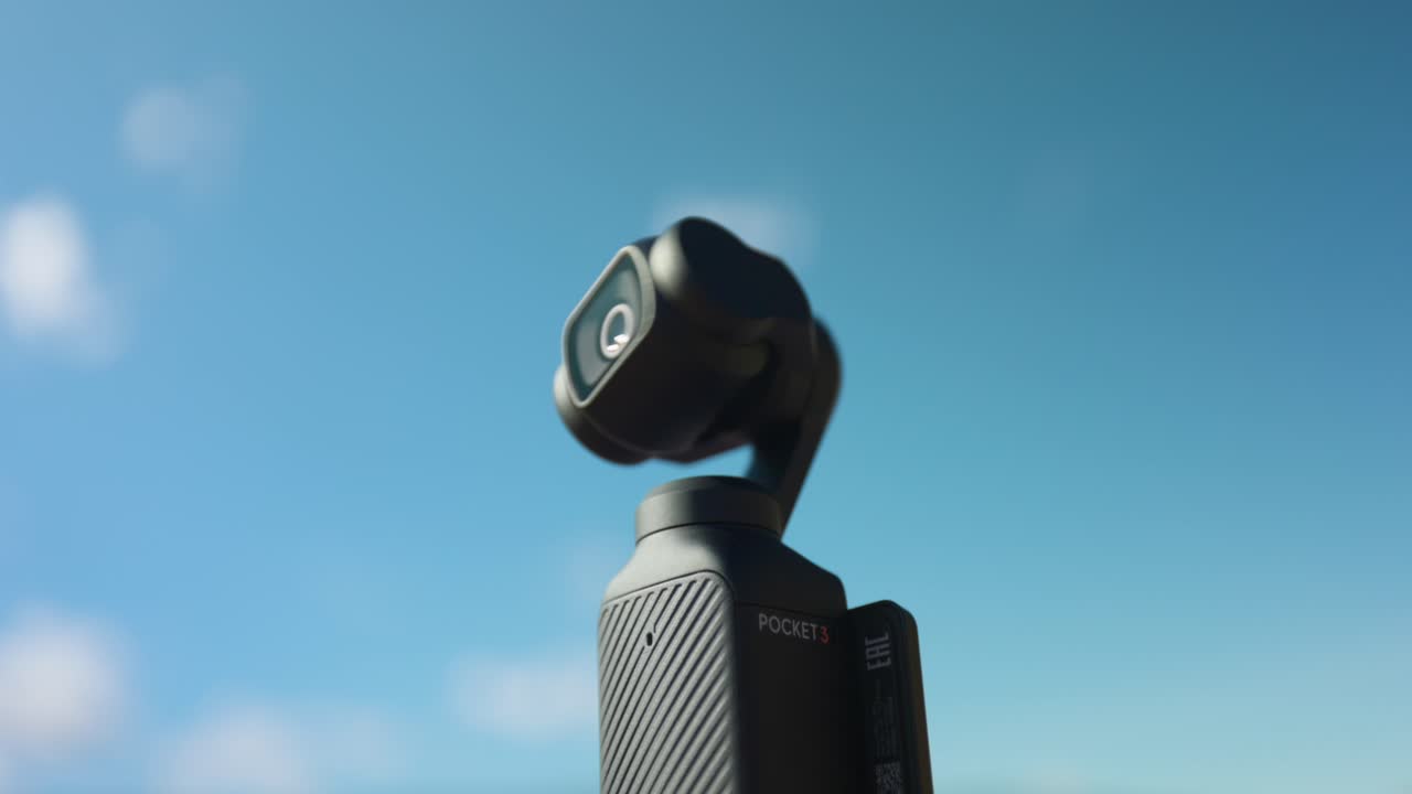 activando el nuevo moderno dji osmo bolsillo 3 estabilizado gimbal portátil cámara móvil compacta con cielo en el fondo para el espacio de copia