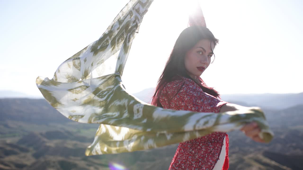 Woman with a flowing scarf in a desert landscape