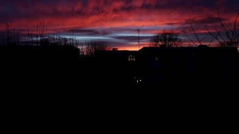 Rollende-Rot-violette-Sonnenuntergangswolke-Im-Zeitraffer-über-Wohnwohnungen