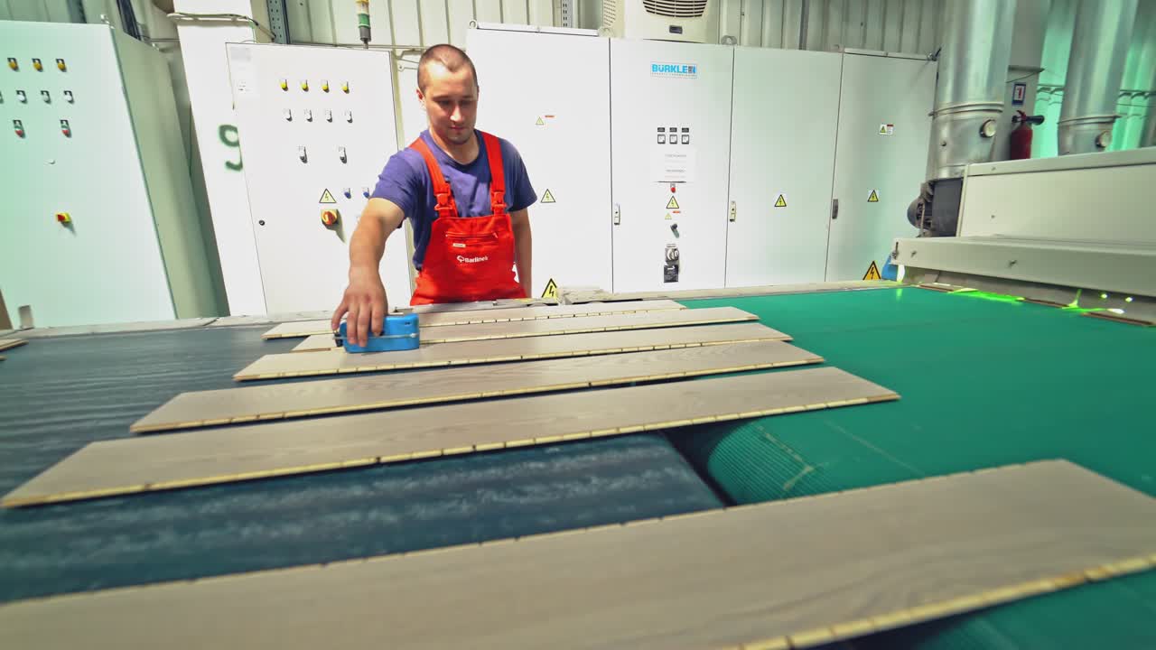 The board moves in a special device. Production line in woodworking factory