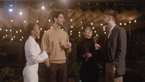 group of four happy multiethnic friends toasting and drinking champagne at new year's eve party 1