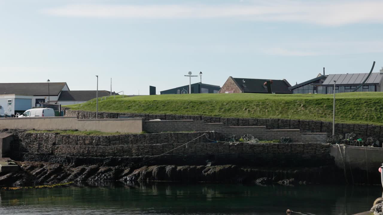 Hand-held shot of the famous John O'Groats Signpost and Harbour on the NC500
