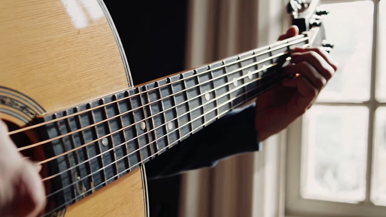 Close-up video of a person playing guitar, focusing on the fretboard and fingers
