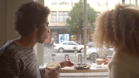 close up of couple enjoying coffee and cake in cafe