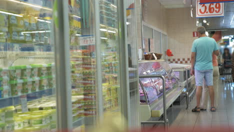 Couple-Walking-along-the-Fridges-in-Supermarket