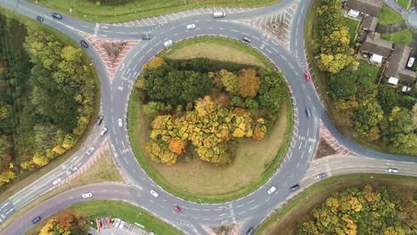 aerial high angle view above congested roundabout traffic in grass urban junction