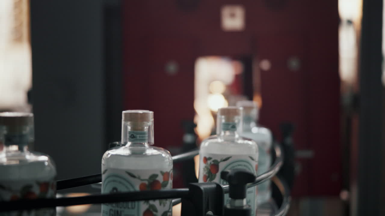 Gin bottles on a conveyor belt in a factory