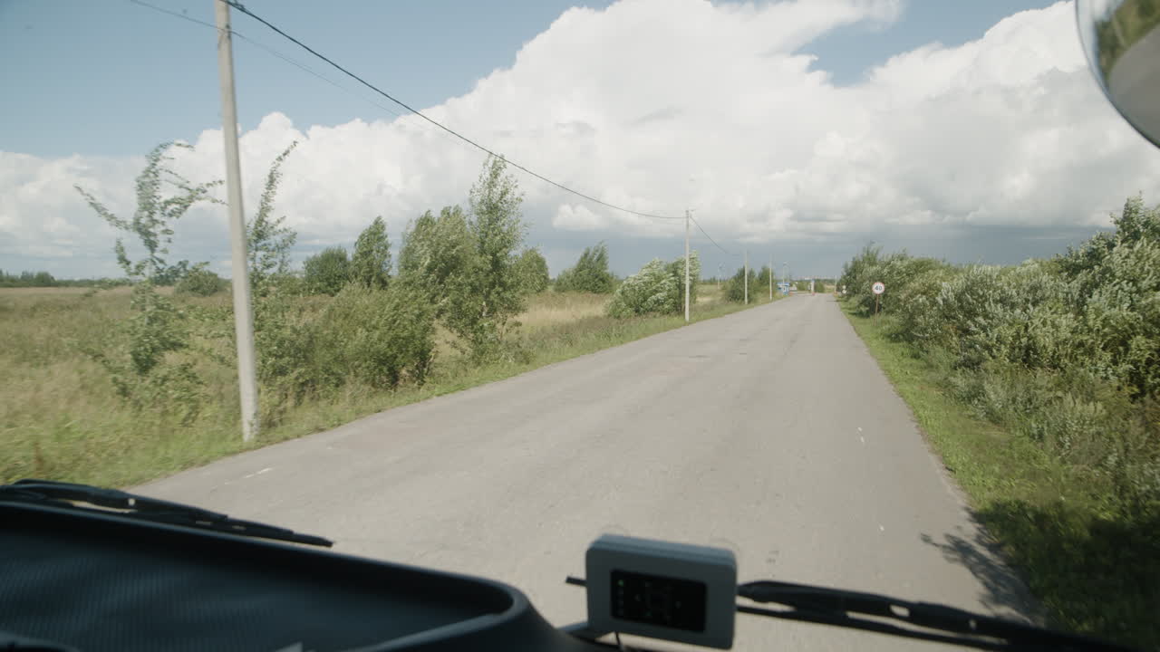 Driving on a rural road under a cloudy sky