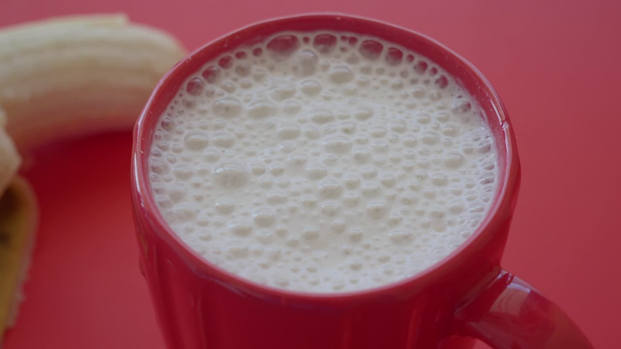 Frullato di banana in tazza rossa