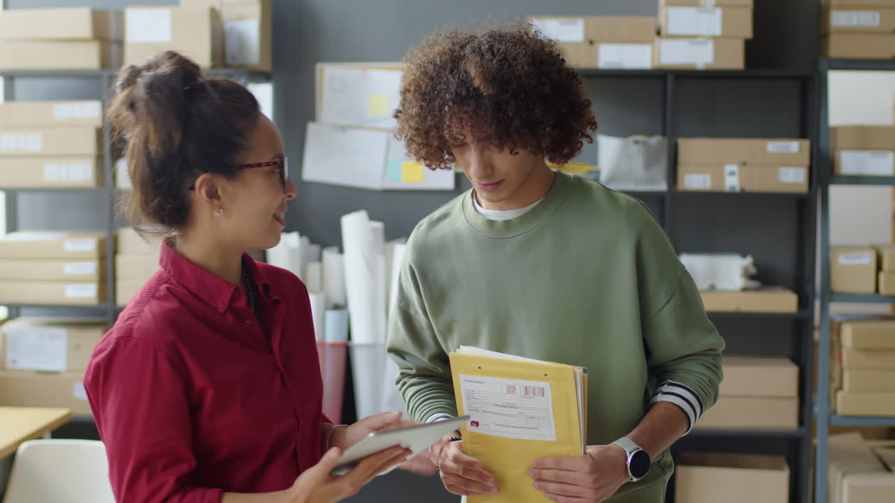 Warehouse employees working with boxes and a tablet