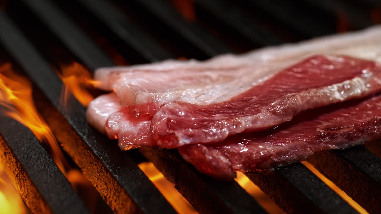 Fire Roasted Bacon Strips Sizzling On A Grill In Slow Motion and Macro, A Summer BBQ Party
