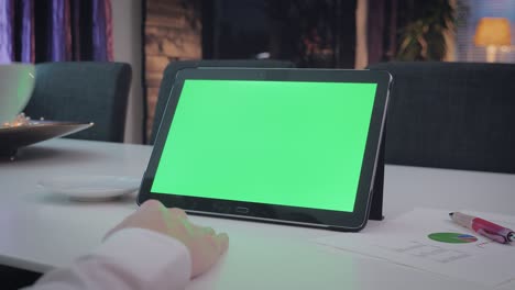 hombre de pantalla verde trabajando en su tableta pc