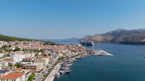 Argostoli city seaside buildings with red tiled roofs, Ferry port with cruise and boats, Kefalonia island, Ionian sea, Drone shot, establishing