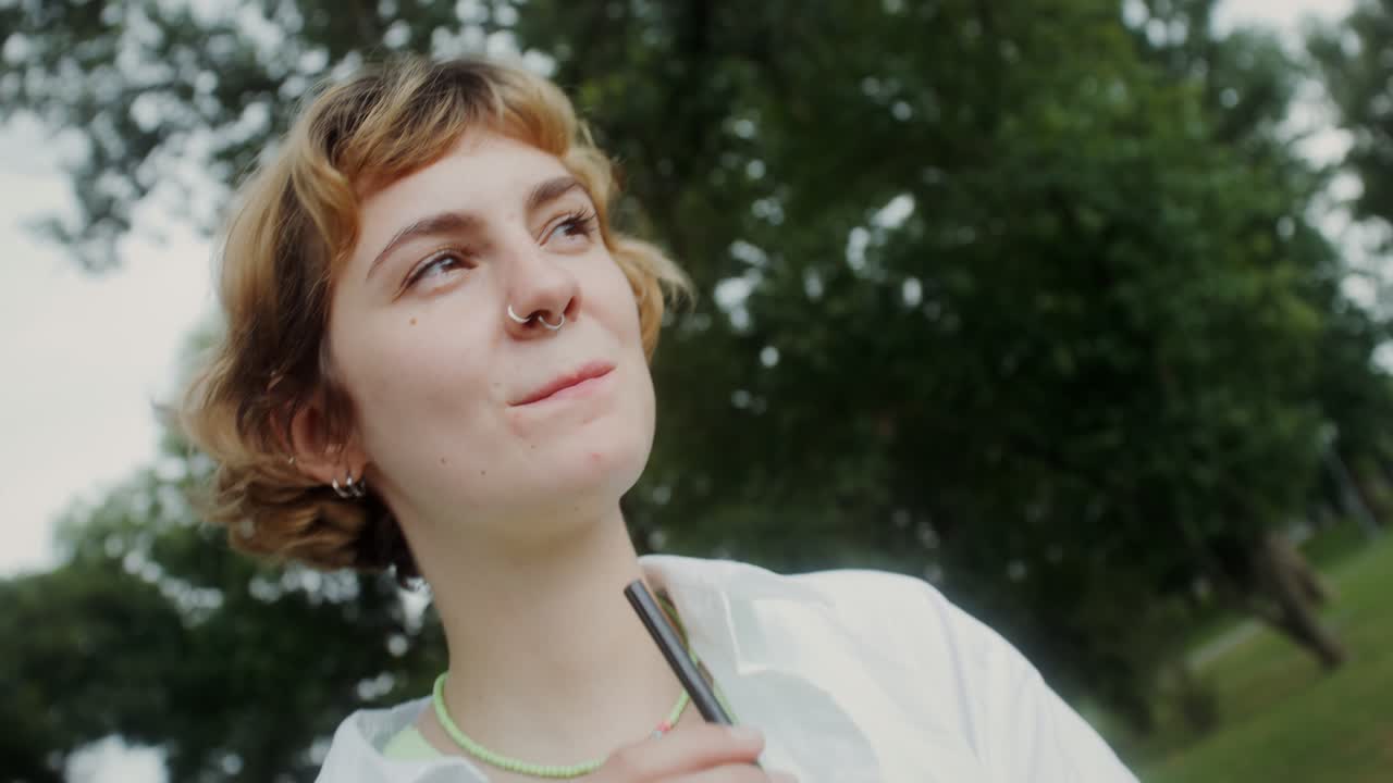 una mujer disfrutando de una copa en un parque.