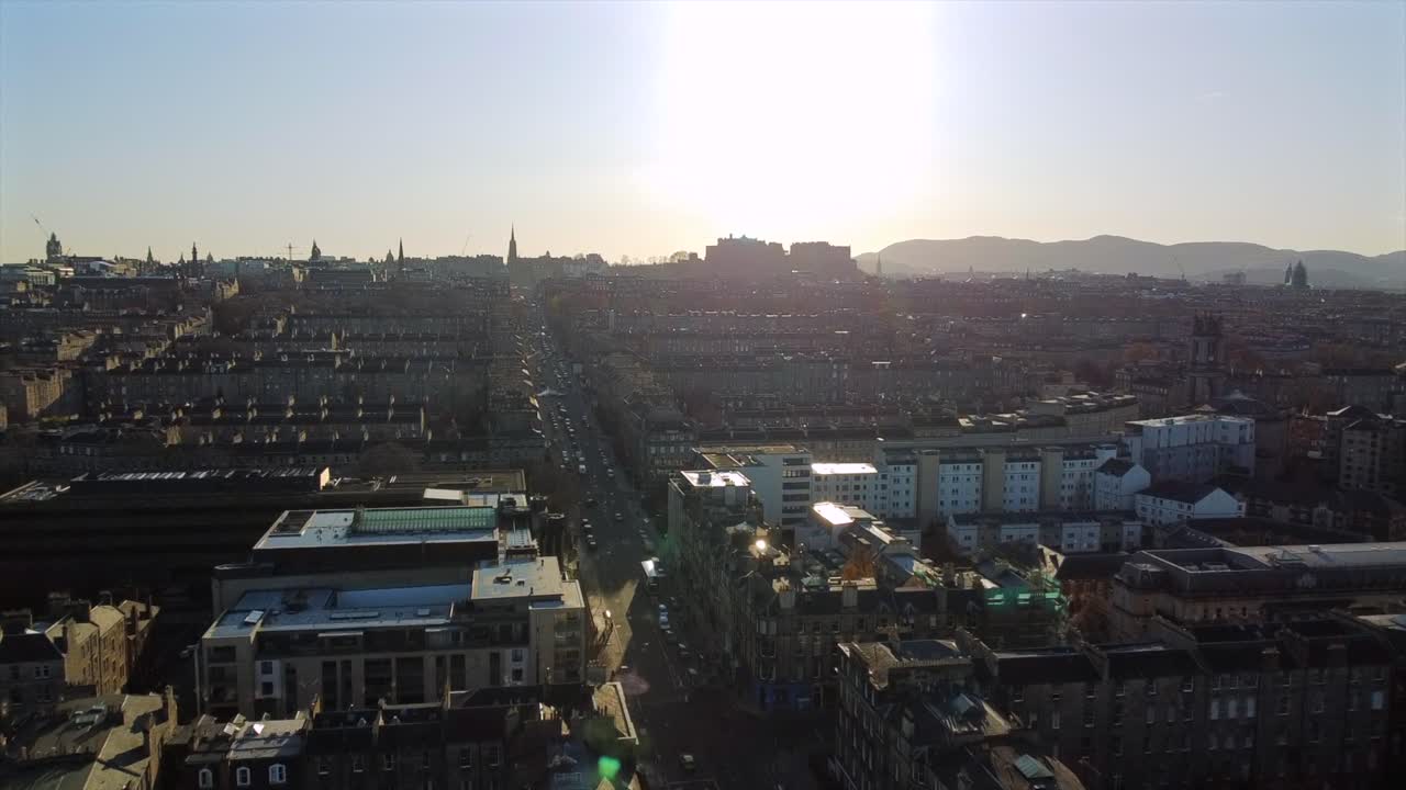 Aerial footage over the streets of Edinburgh, Scotland, during sunset. The shot captures the iconic Edinburgh Castle and the city’s historic skyline.
