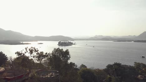 4k-aerial-footage-of-Taj-Lake-Palace-on-Lake-Pichola-of-the-lakeside-city-of-Udaipur,-India