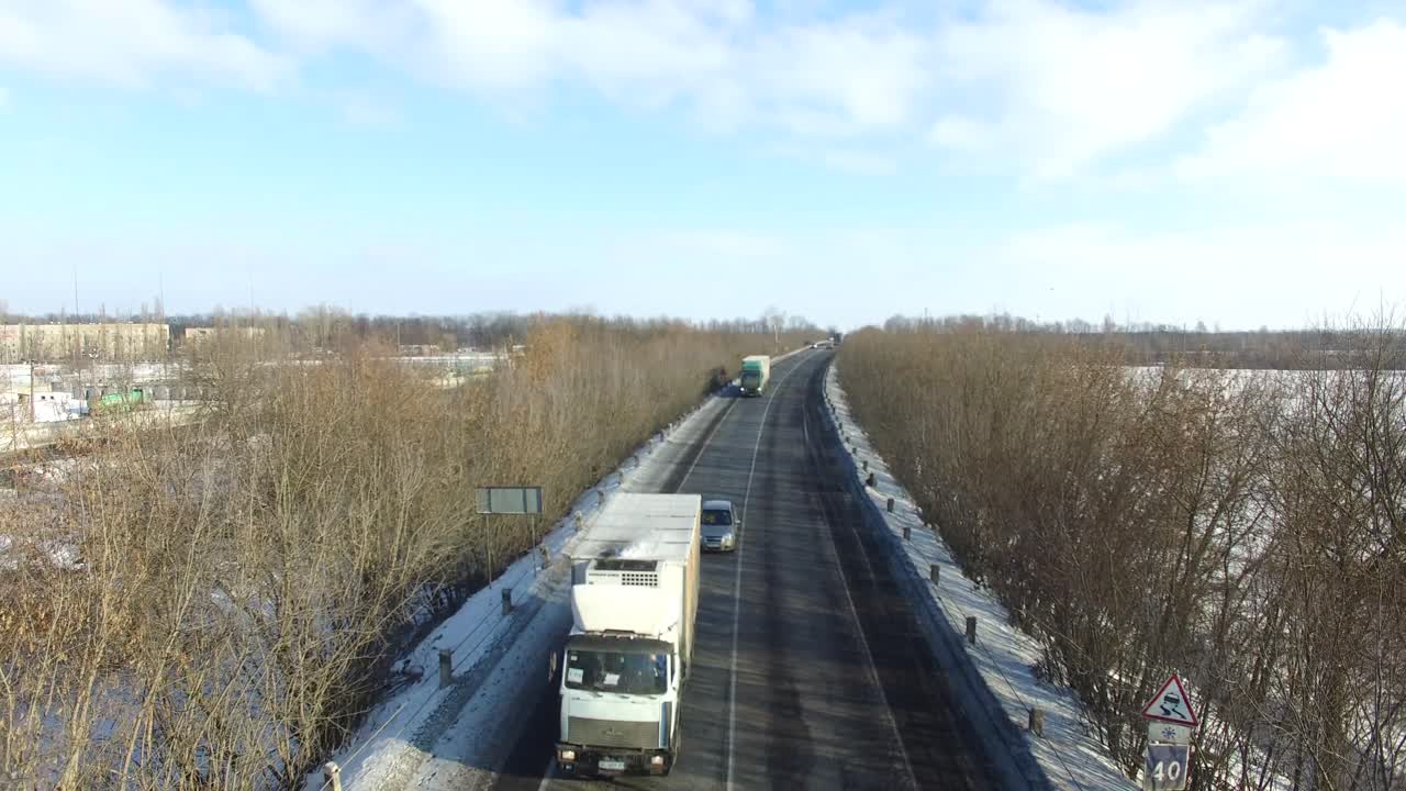 Road in winter. Aerial view of snowy highway road around trees