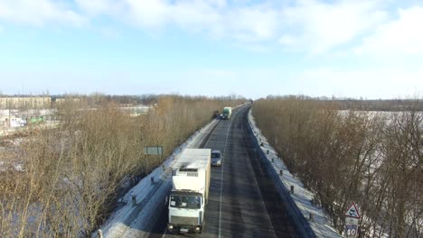 road in winter. aerial view of snowy highway road around trees