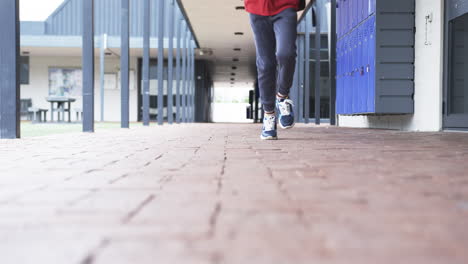 In-a-school-corridor,-a-young-Caucasian-boy-is-in-motion-with-copy-space