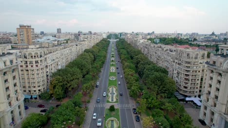 aerial view of unirii boulevard, near unirii square in bucharest, romania surrounded by tall apartment building, lush vegetation and beautiful water fountains, city center, cars, traffic