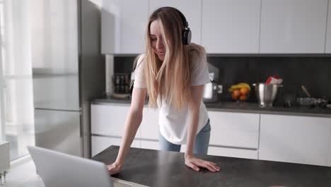 Chica-Rubia-En-La-Cocina-Está-Bailando-Y-Divirtiéndose-Con-Auriculares