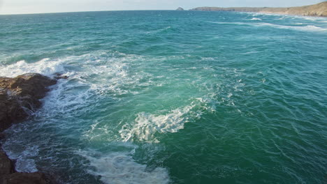 Vista-De-Espumosas-Olas-Verdes-Turquesas-Salpicando-Rocas-Costeras-Desde-El-Acantilado,-Cornualles---Cámara-Lenta