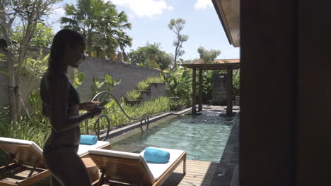 beautiful woman by poolside in luxury resort in bali indonesia