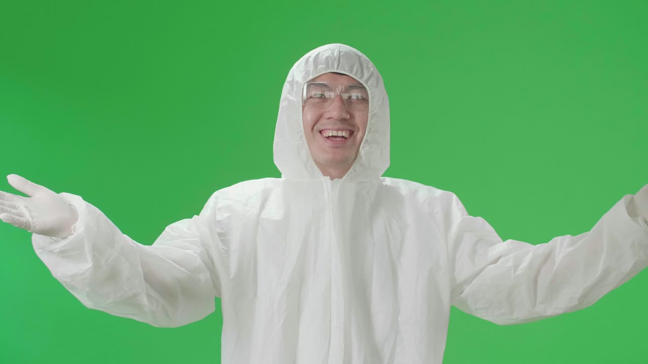 Male Wearing Personal Protective Equipment Uniform Ppe Blowing Kisses To A Camera In The Green Screen Studio