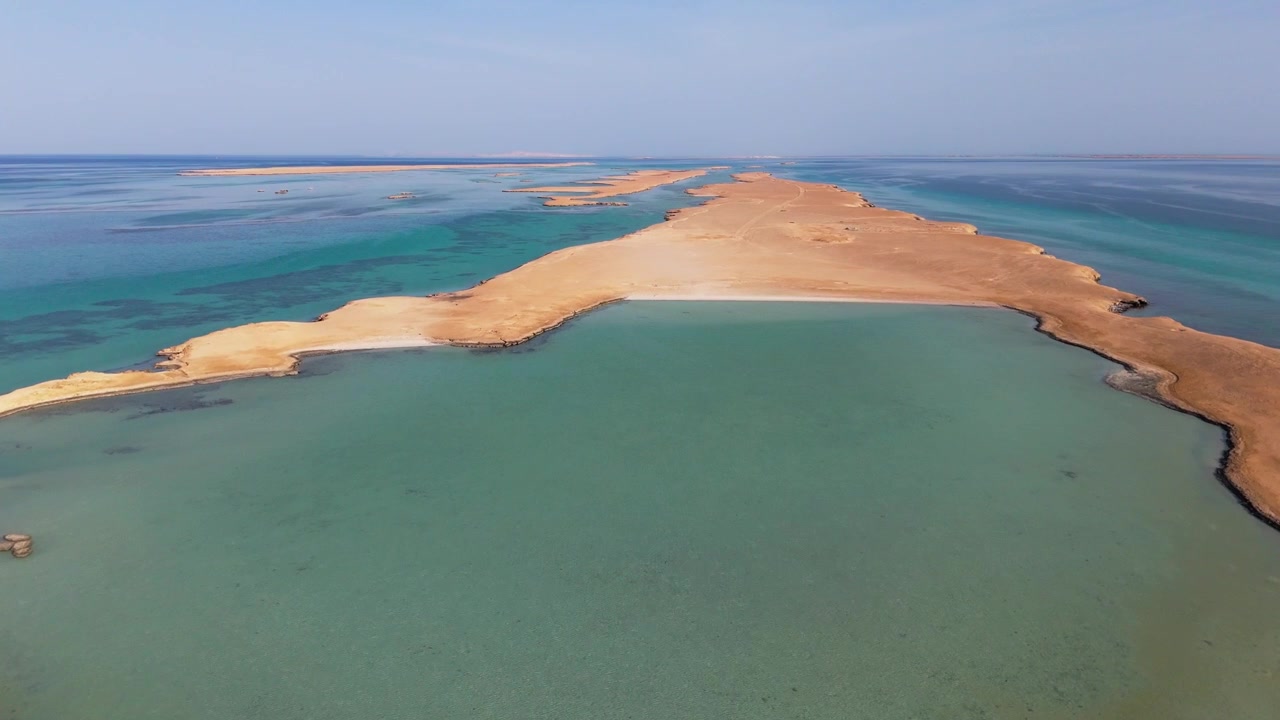 Luftoptagelse af Juzur Ashrafi-øen, Egypten, der viser levende turkise farvande og barske klipper på et isoleret og fjerntliggende sted i Det Røde Hav.