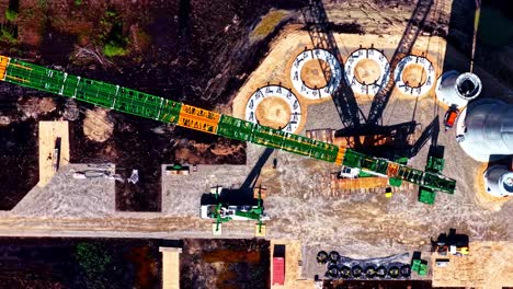 wind turbine bases and towers being erected for clean, efficient energy - straight down sliding aerial view