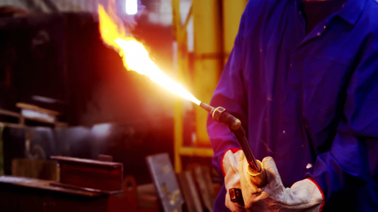 Male engineer using welding torch 4k