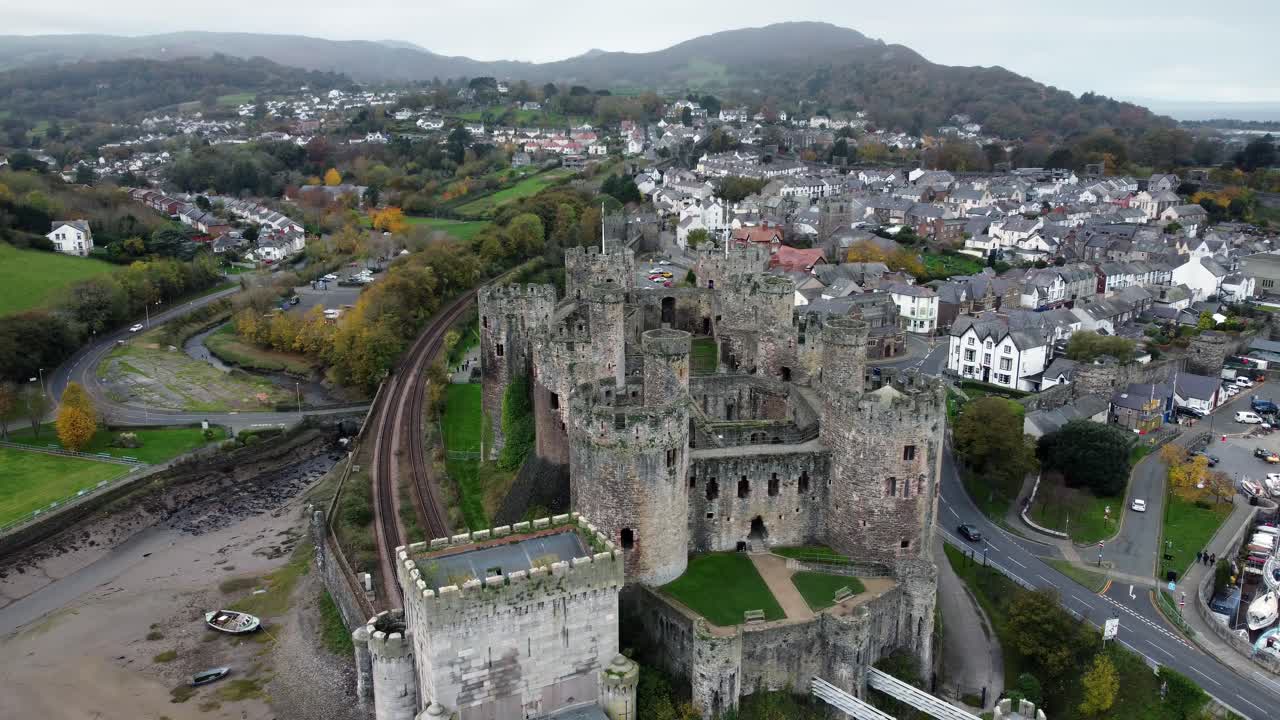 Vista aerea del Castello storico di Conwy, con rovine di una città, merlature in pietra, attrazione turistica, discesa da alta a bassa verso sinistra.