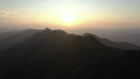 aerial drone view of spectacular golden sunset behind mountain silhouette over ceiling