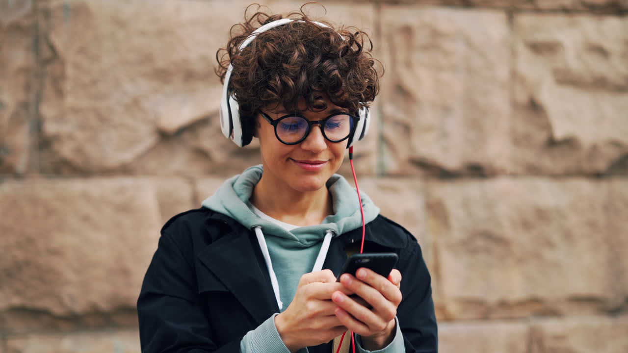 mujer escuchando música y usando el teléfono al aire libre