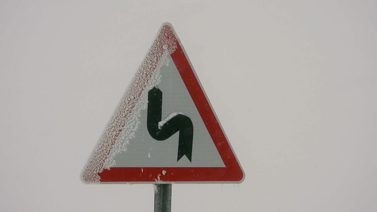 Winding Road Traffic Sign Covered in Frost During Winter